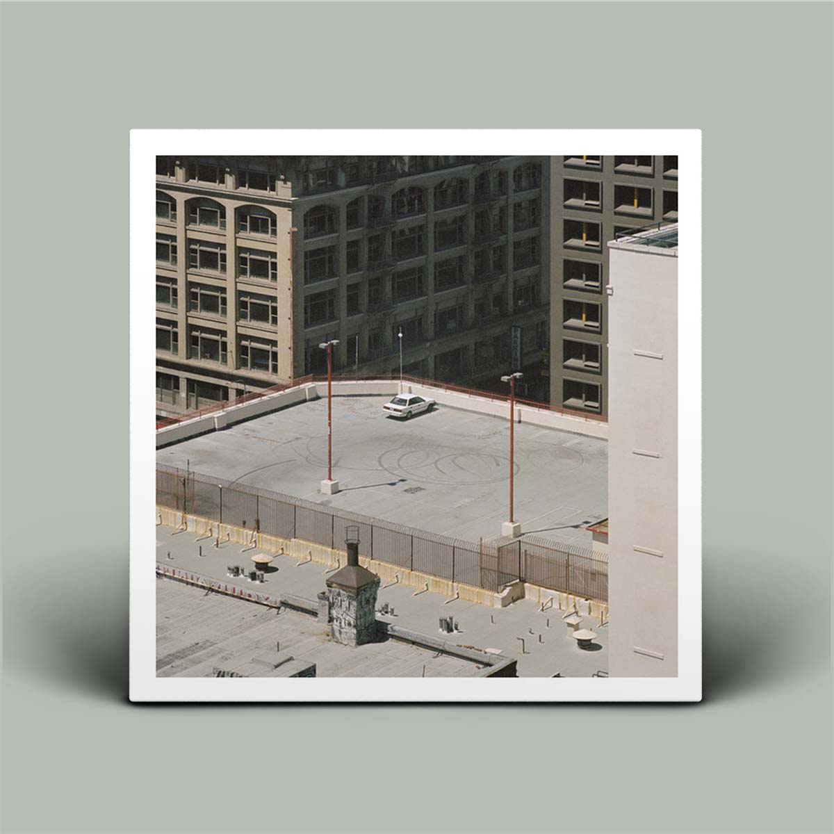 Framed photograph of a cityscape with buildings and a rooftop scene.