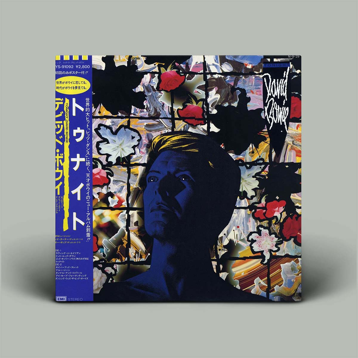 Vinyl record cover with a stylized portrait and colorful abstract design, featuring the artist's name on a gray background.