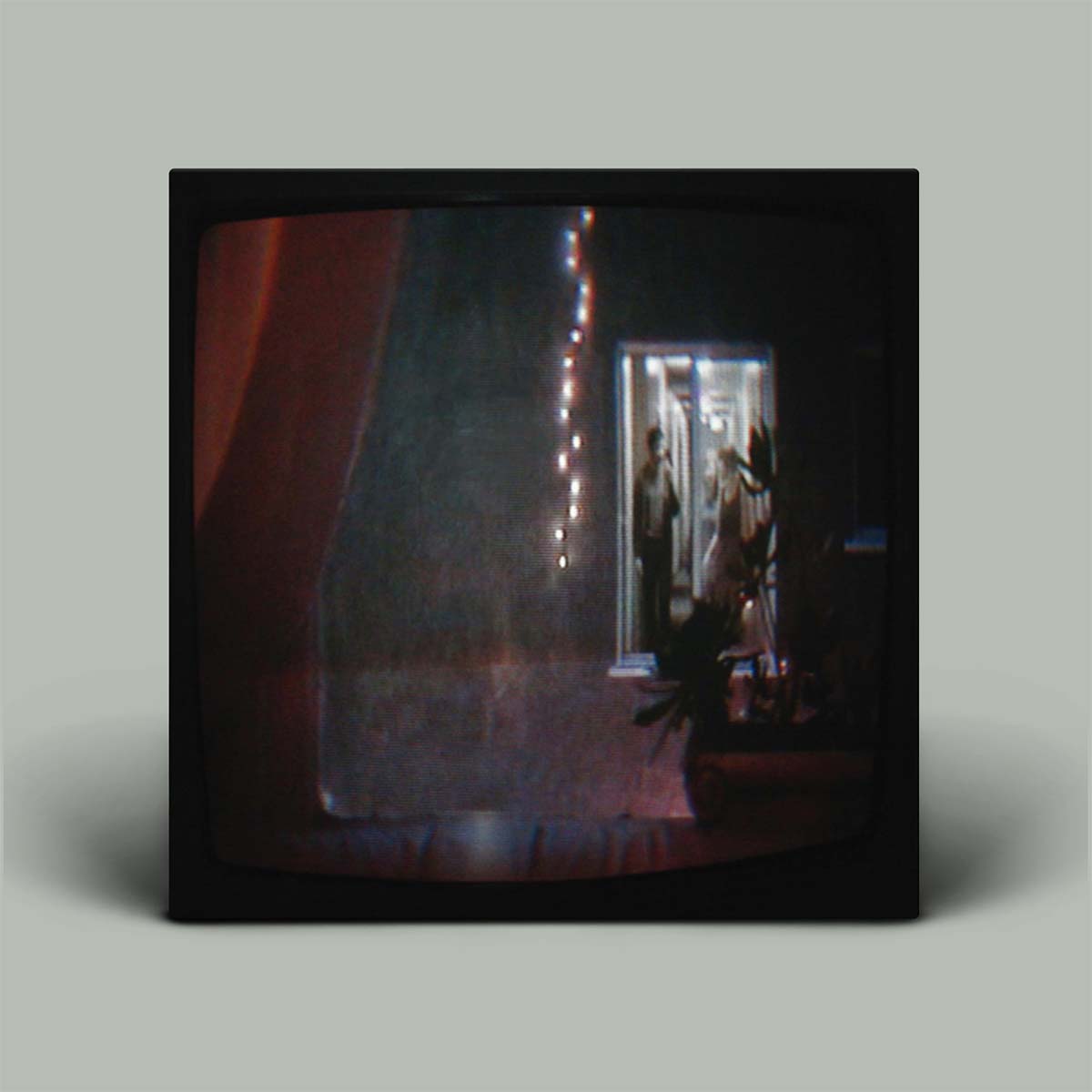 Album cover with a photograph of a room with a mirror and decorative lights on a gray background
