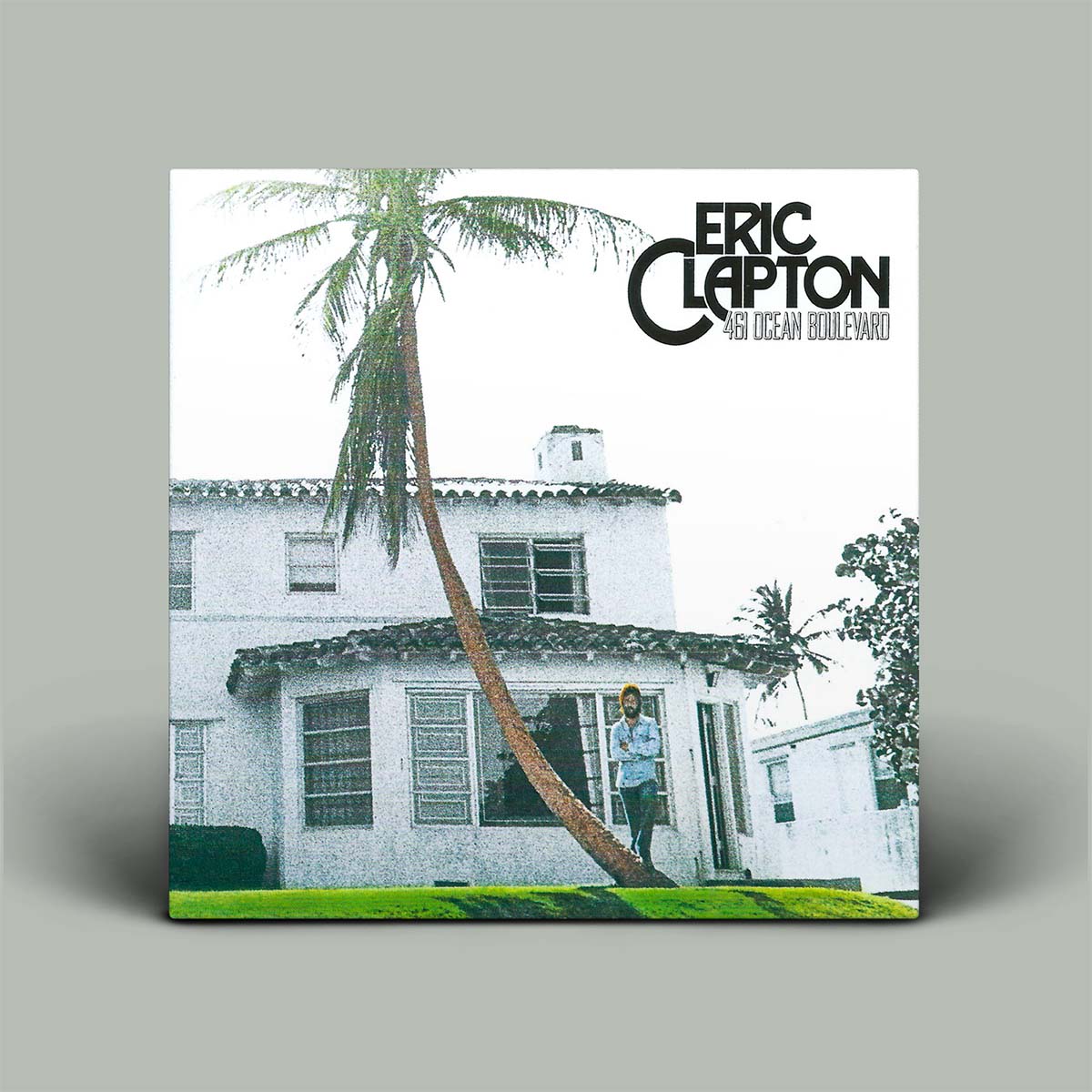 Album cover with a house and palm tree, featuring Eric Clapton's name.