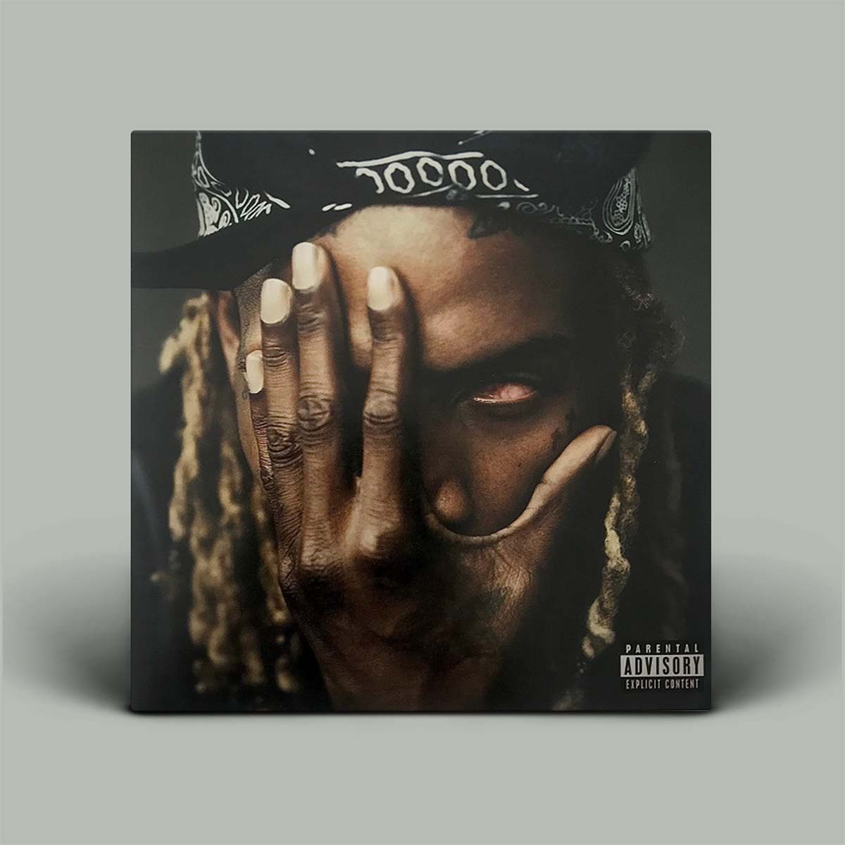 Album cover with a person wearing a cap and holding their hand to their face on a gray background