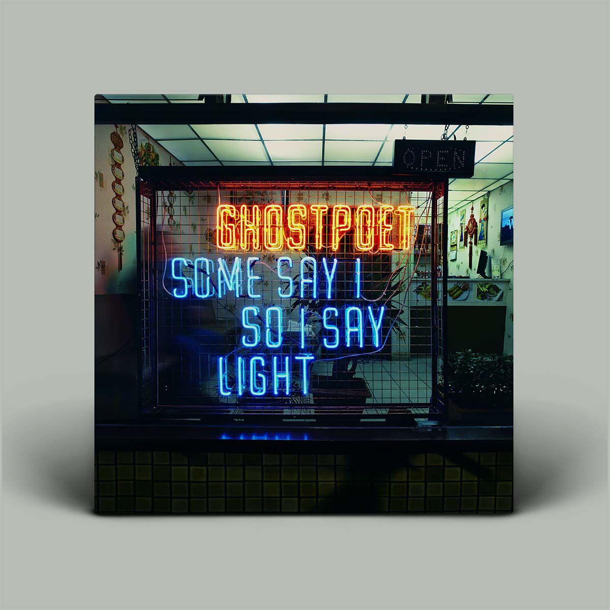 Album cover with neon text 'GHOSTPOET SOME SAY I SO I SAY LIGHT' in a store setting.