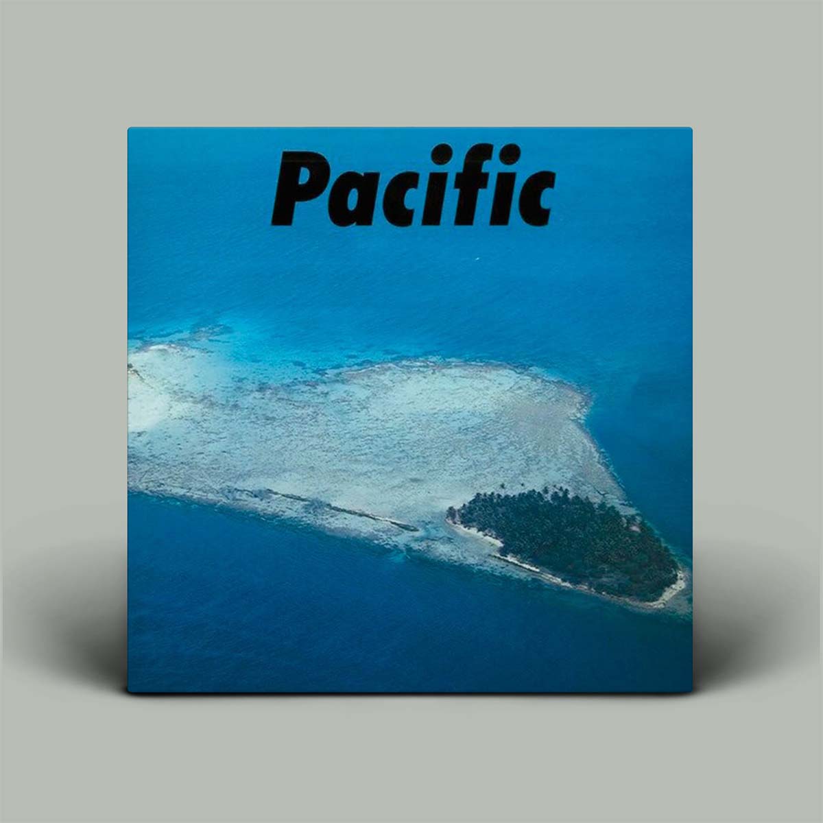 Album cover with an aerial view of a Pacific island and the word 'Pacific' on a blue background.