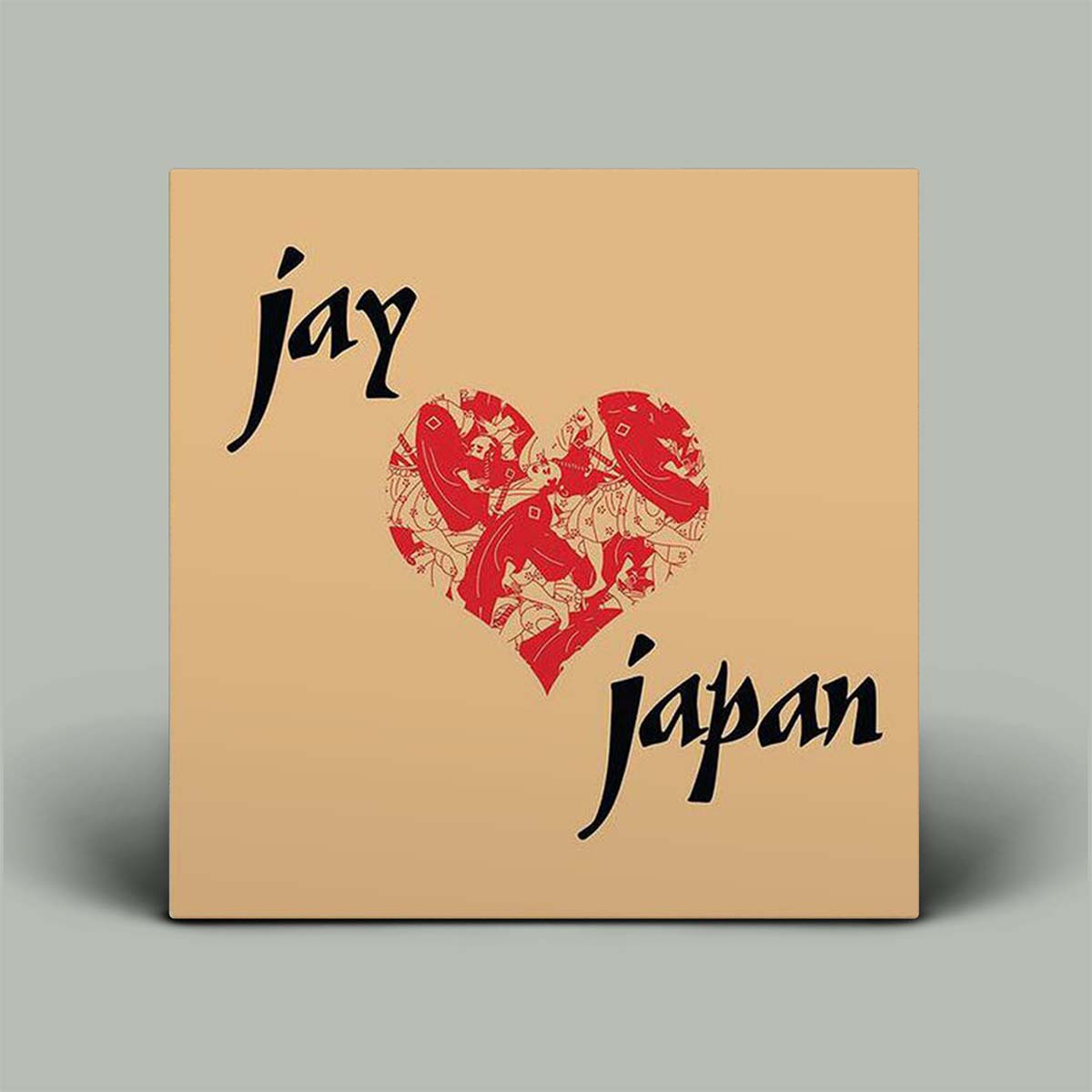 Square brown cardboard box with red heart design and text 'jay' and 'Japan' on a gray background