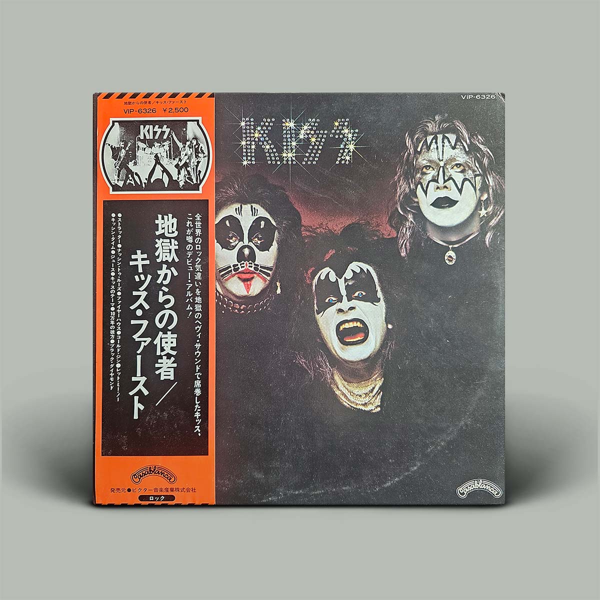 Vinyl record cover with band members' faces and text on a gray background