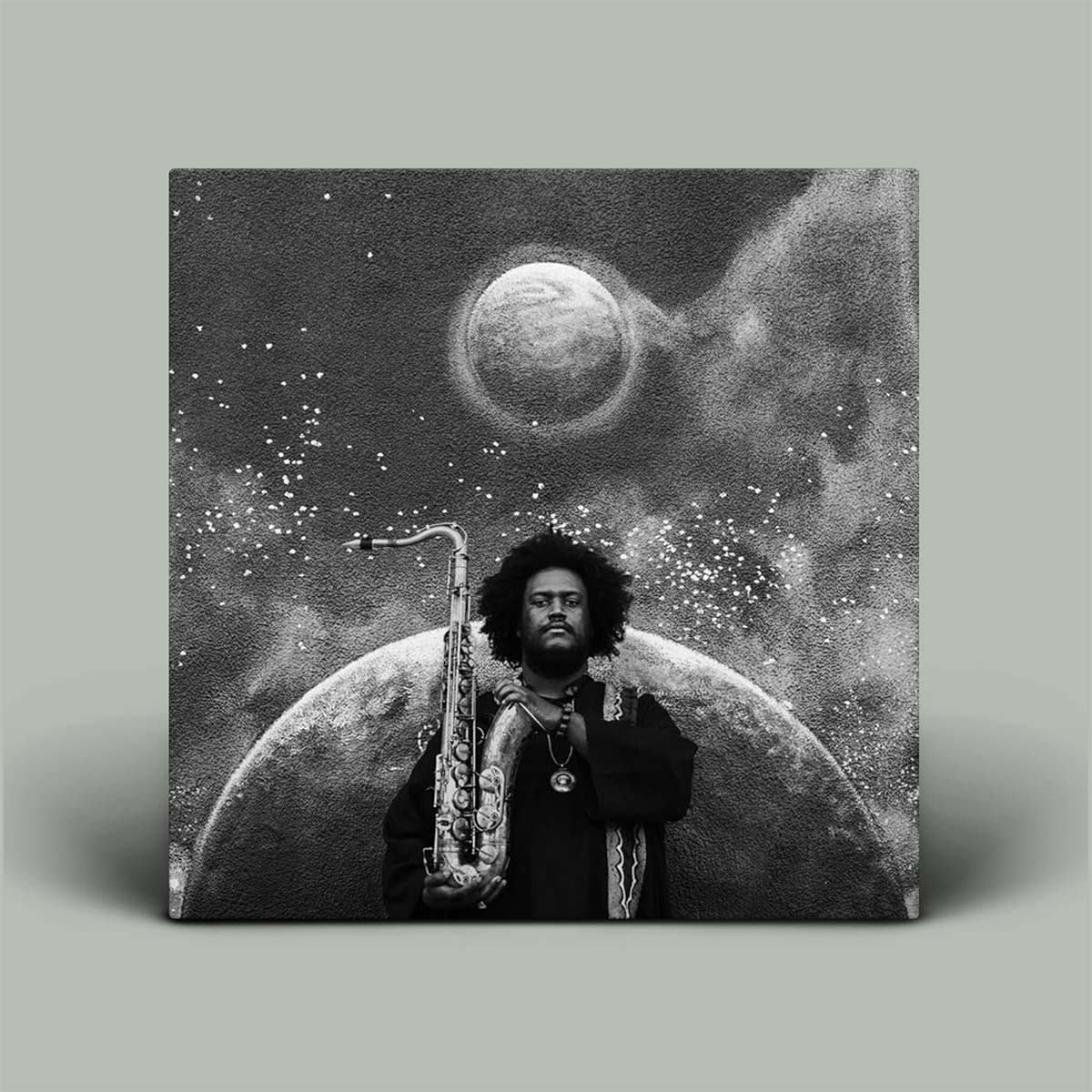 Black and white photo of artist with saxophone in front of an image of the moon.