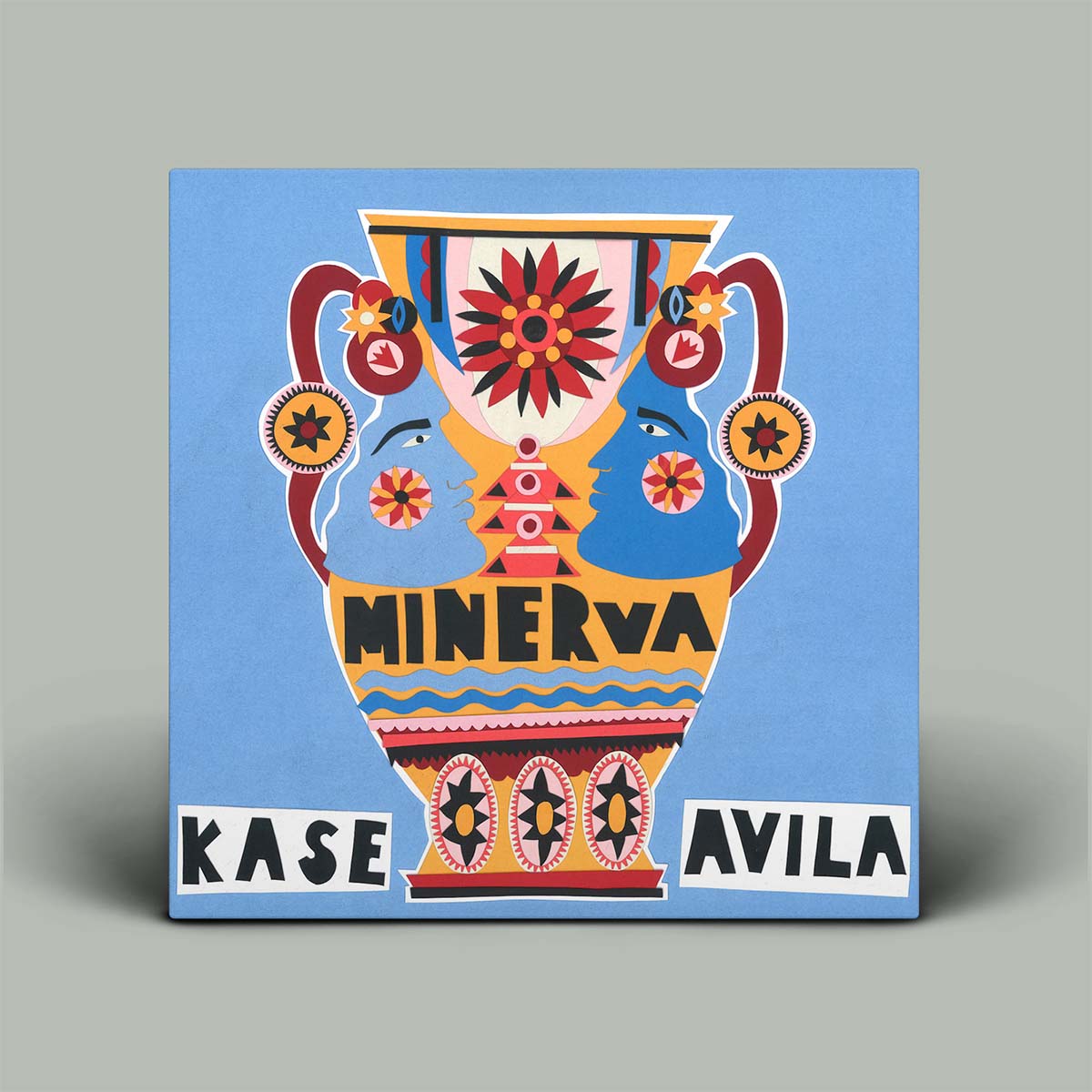Decorative tile with a colorful vase design and 'Minerva Kase Avila' text on a blue background