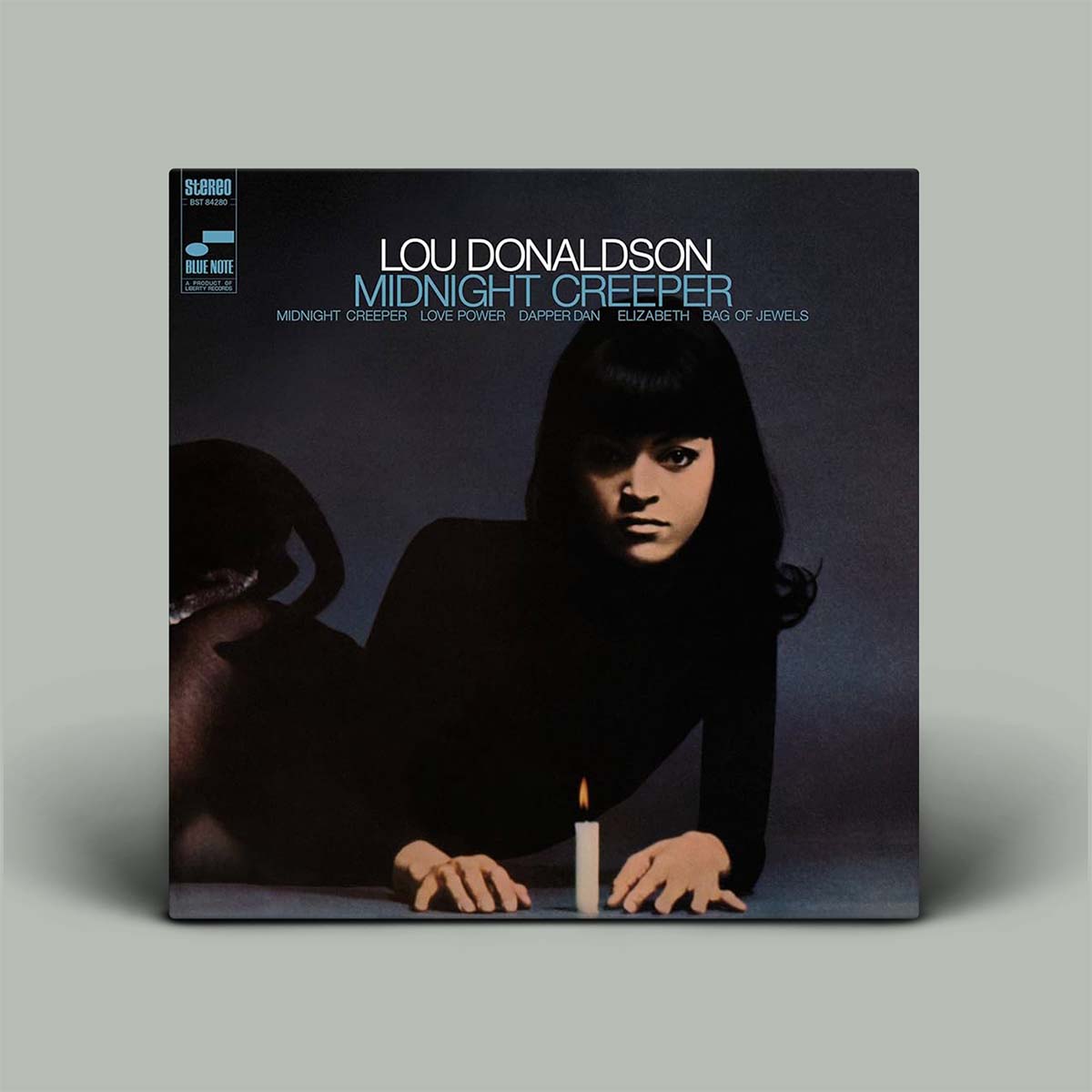 Vinyl album cover with a person holding a candle and text 'Lou Donaldson Midnight Creeper' on a gray background