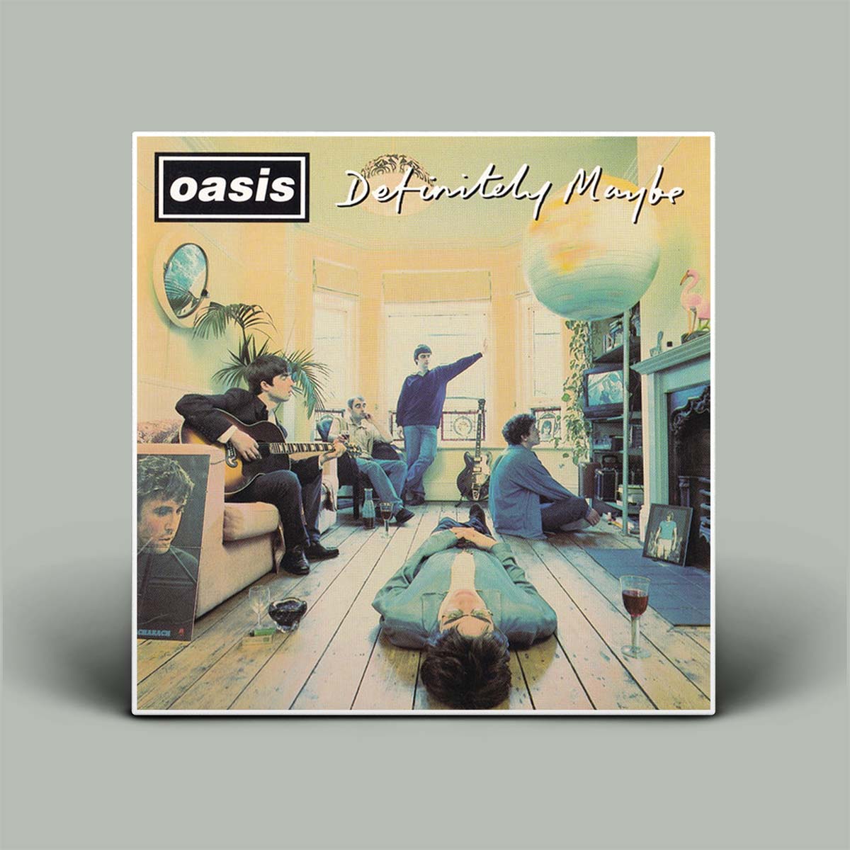 Album cover for 'Definitely Maybe' by Oasis featuring a group of people in a living room.