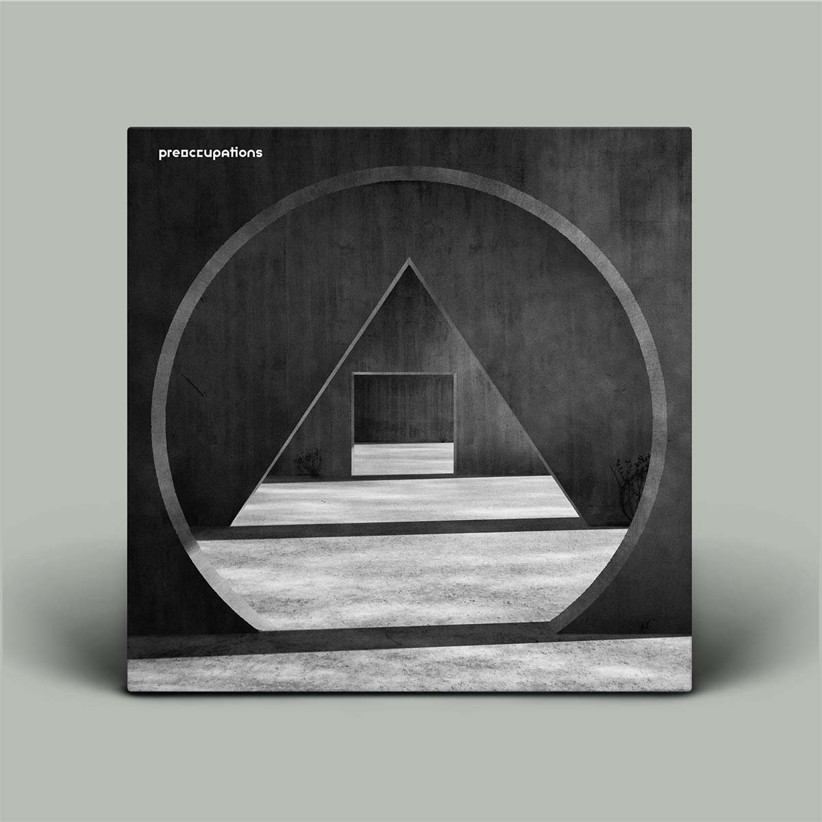 Album cover with geometric design and 'preoccupations' text on a gray background