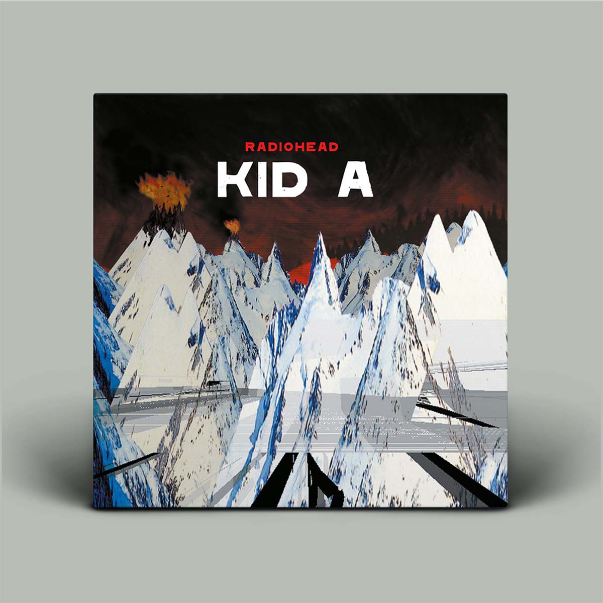 Album cover for 'Kid A' by Radiohead with mountain and abstract design on a gray background
