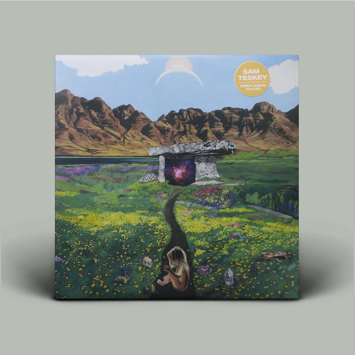 Album cover with a landscape scene featuring mountains, a lake, and a person sitting on a rock.