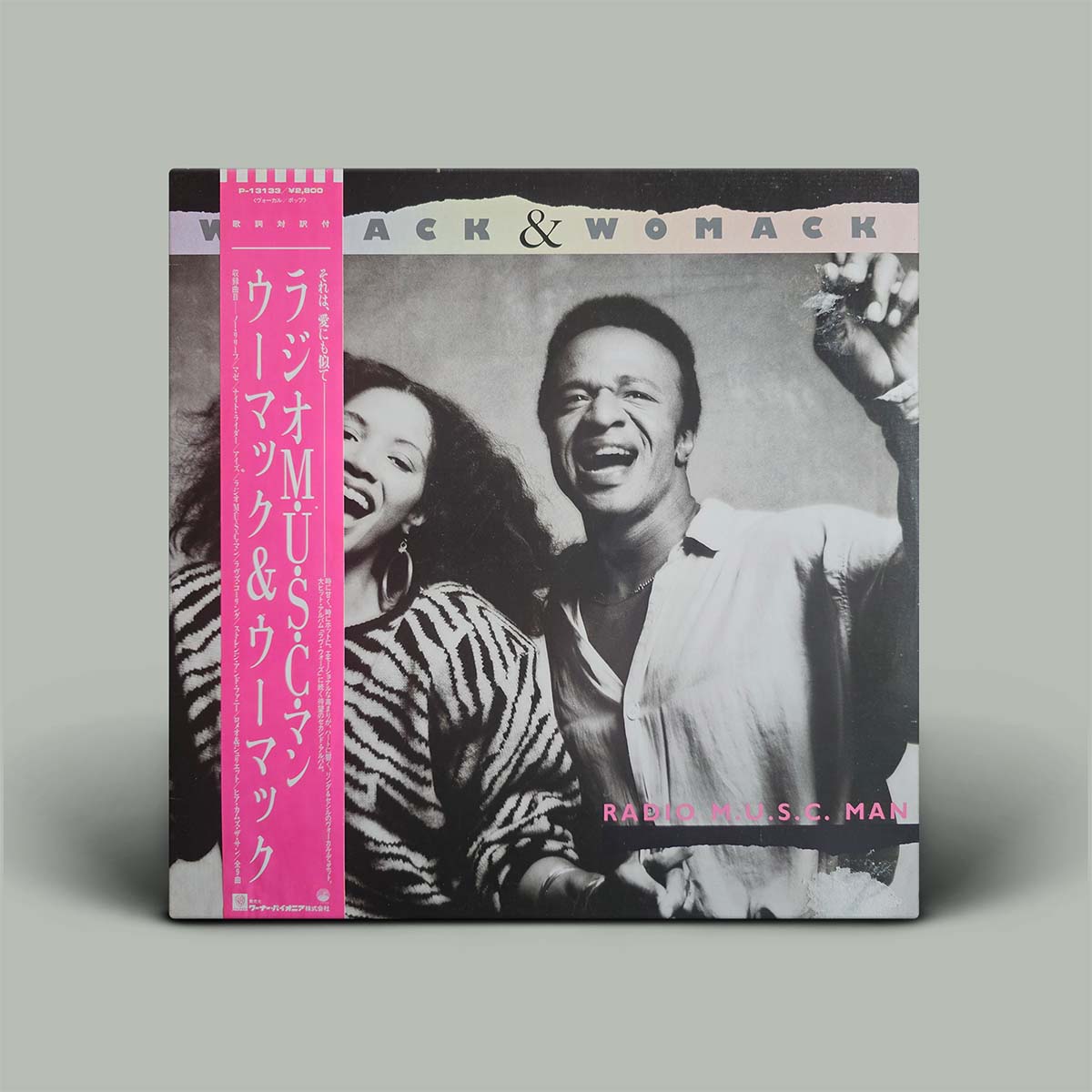 Album cover with black and white photo of man and woman shouting with pink obi strip.