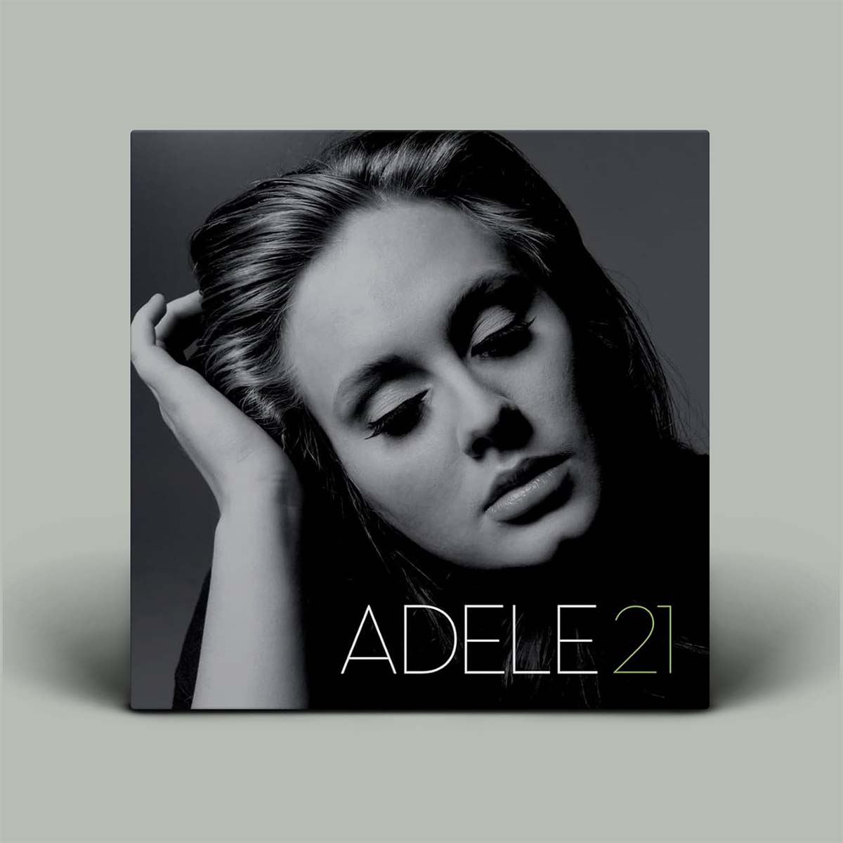 Album cover of 'Adele 21' with a black and white portrait of Adele on a gray background