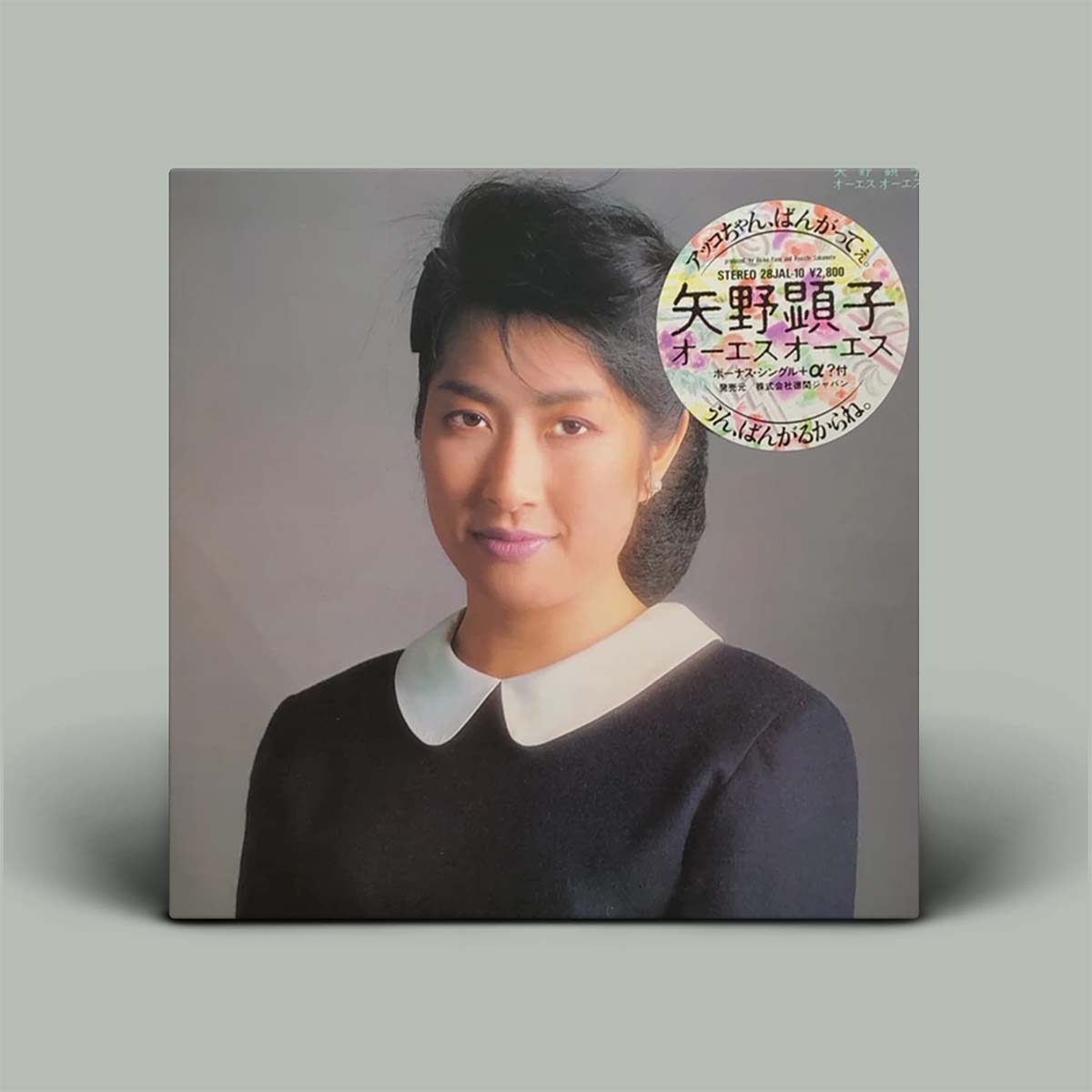 Album cover with portrait photograph of Akiko Yano on grey background.