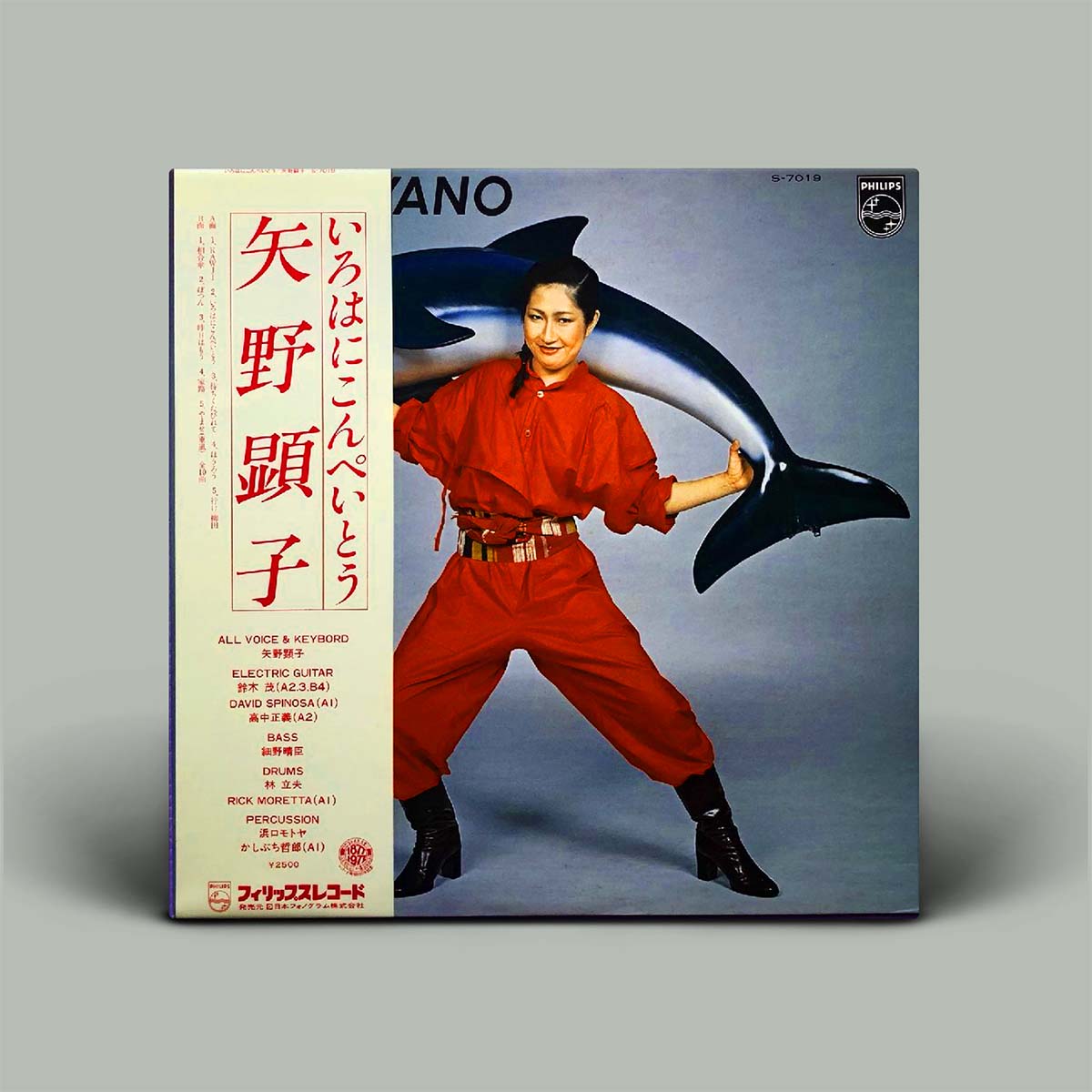 Vinyl record album cover for 'Iroha to Ningen' by Yoko Ono, featuring a photo of her in a red jumpsuit with a shark on a gray background, with tracklist text on the left side.