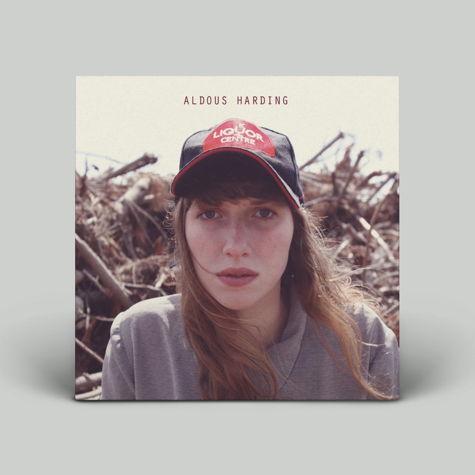 Album cover with a person wearing a cap and text 'Aldous Harding' on a natural background