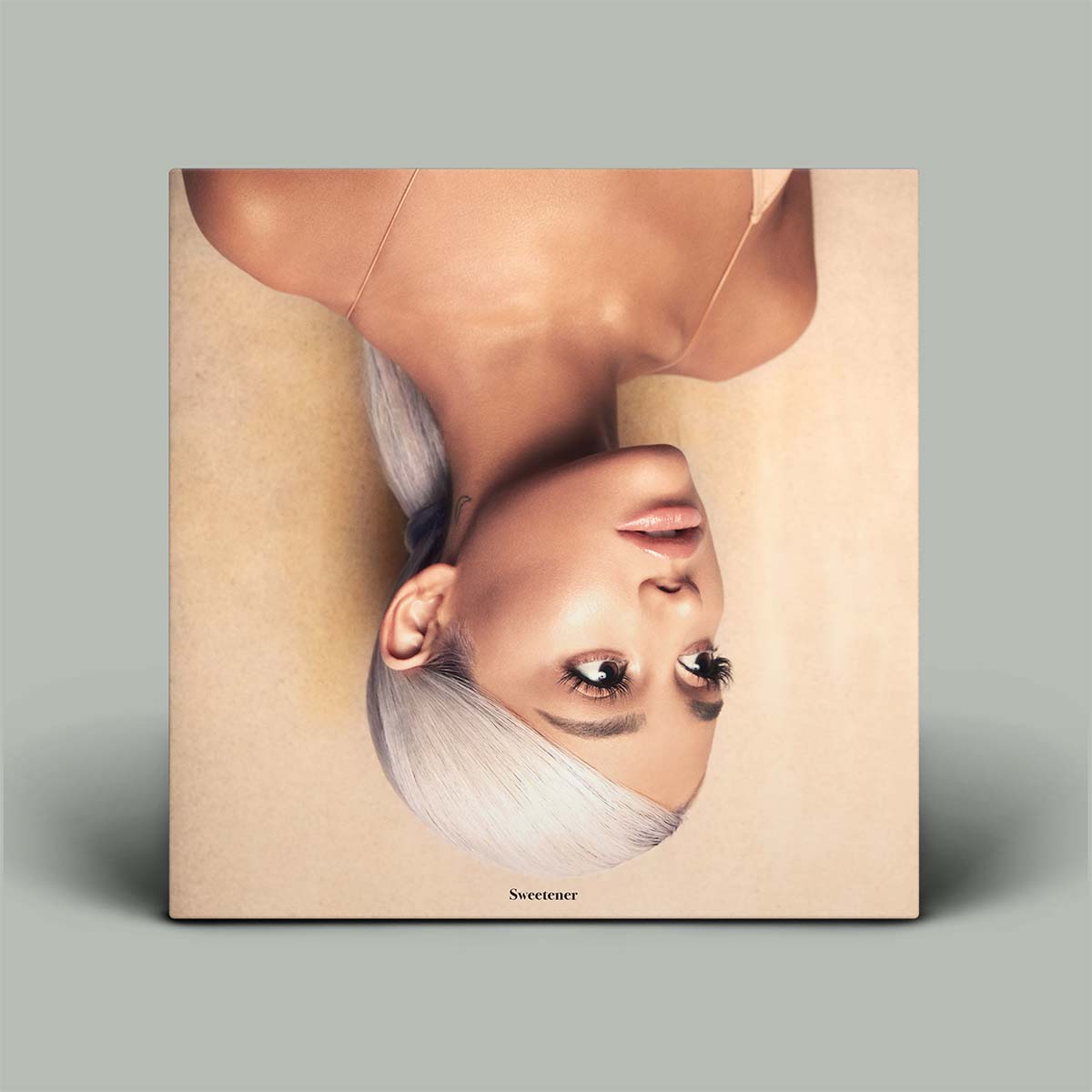 Album cover with a portrait face upsode down on a beige background