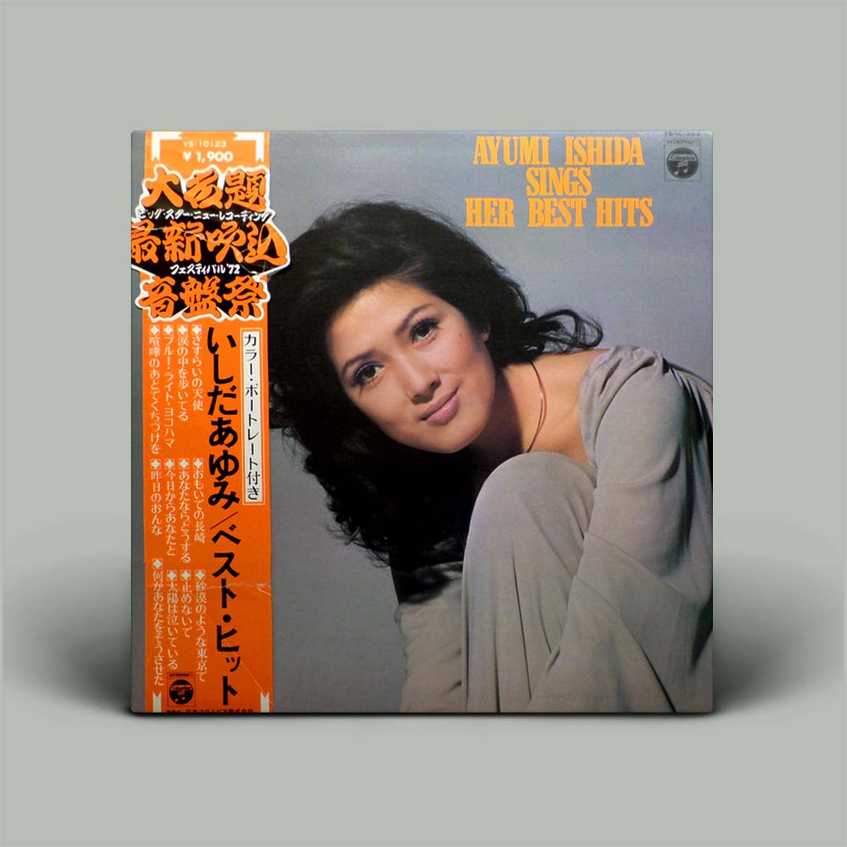 Vinyl album cover featuring a woman with text and graphics on a gray background