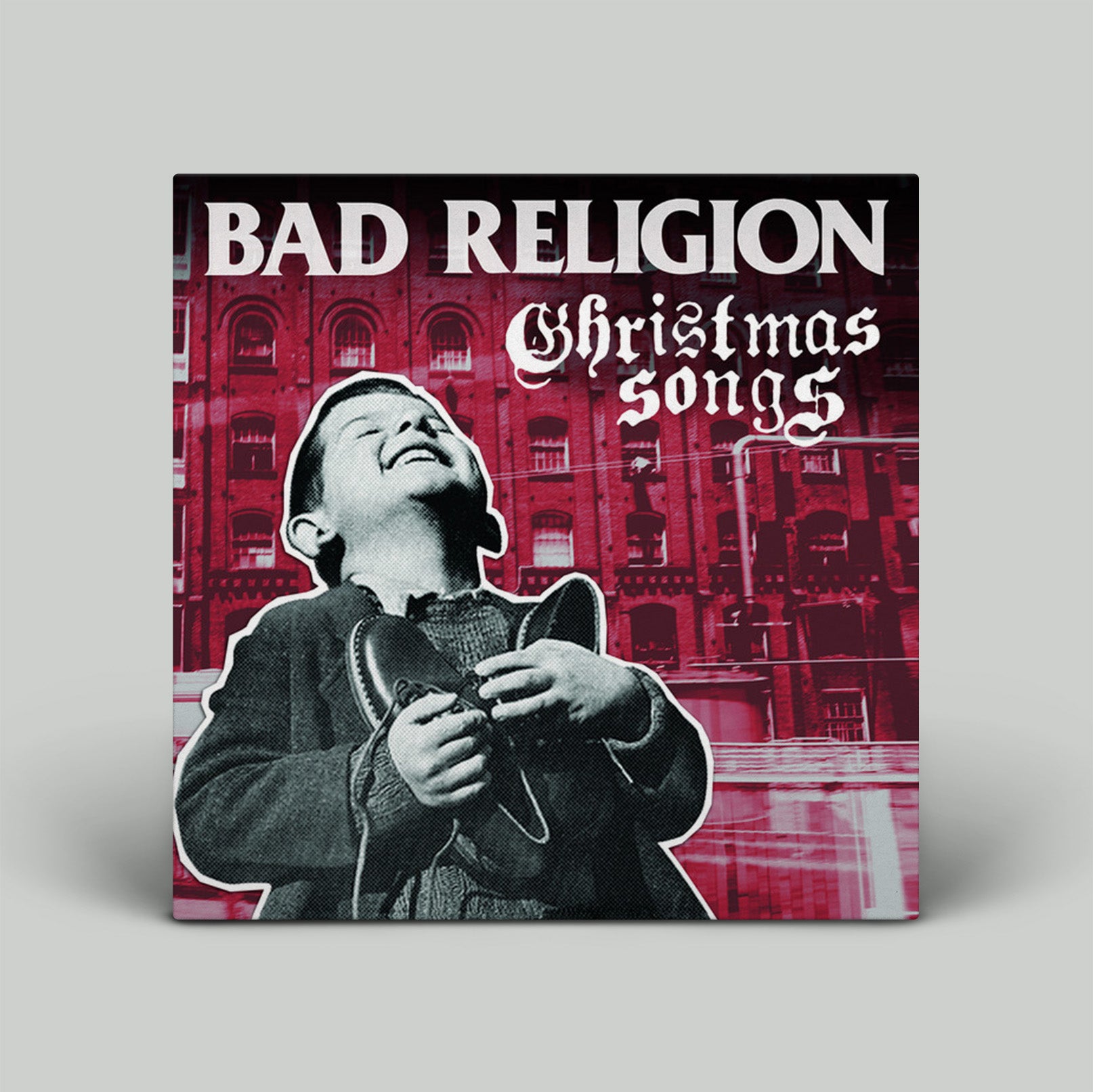 Album cover for 'Bad Religion Christmas Songs' with a person in a coat against a red building background.