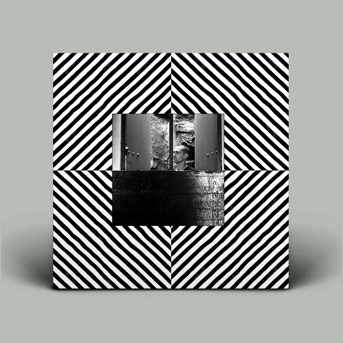 Album cover with black and white geometric pattern and central cutout