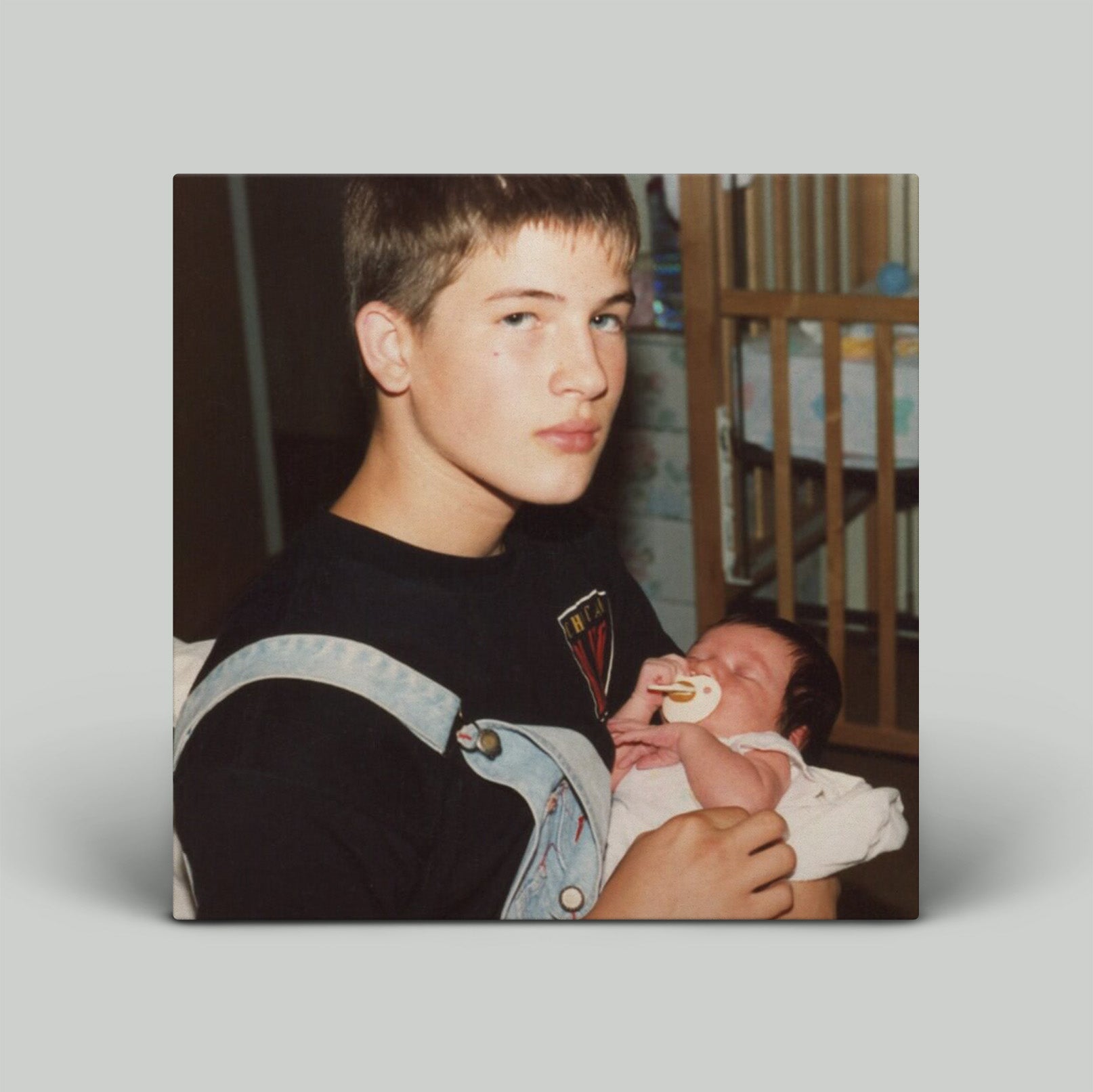 Person holding a baby with a neutral background