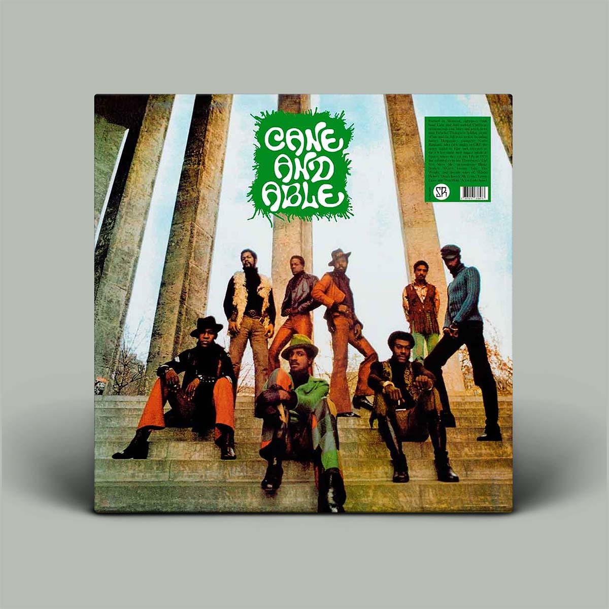 Cane and Able vinyl record album cover displayed upright against a neutral gray background. The square cover features the band members posed on stone steps under large columns, with a bright green jagged logo reading 'CANE AND ABLE' near the top and a green barcode sticker on the right.