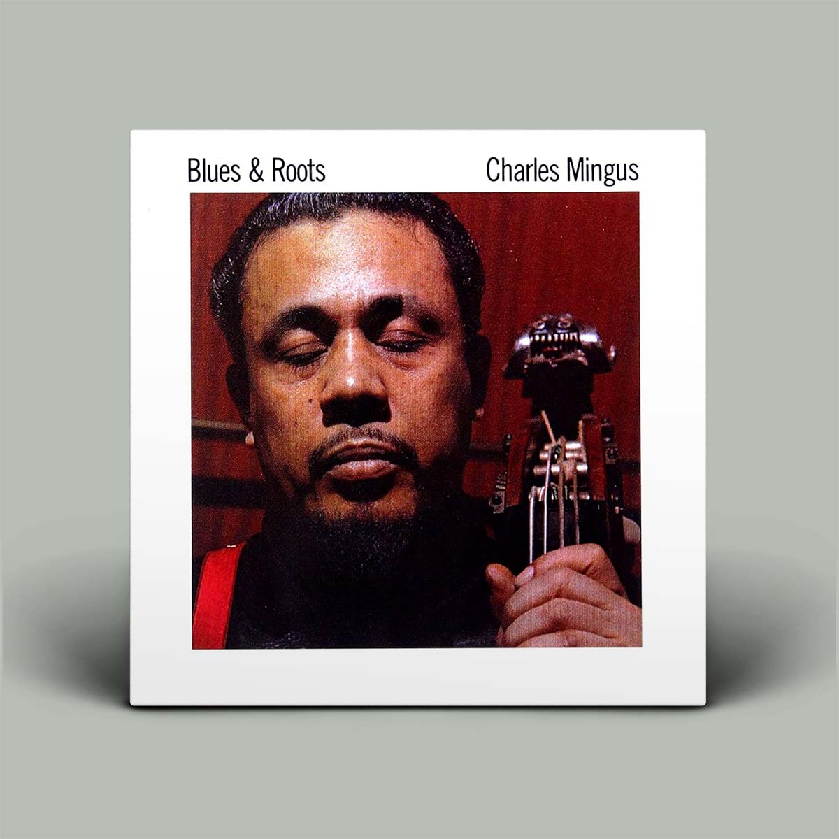 Album cover of 'Blues & Roots' by Charles Mingus with a close-up of the musician holding a trumpet.