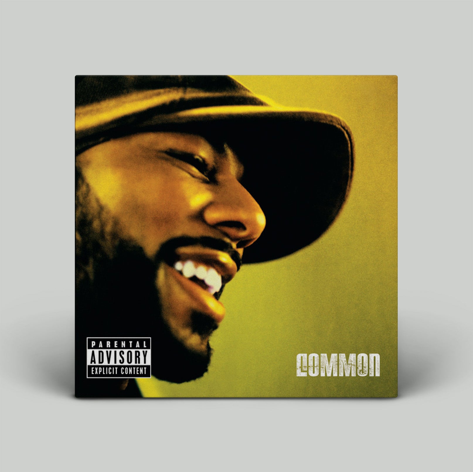 Album cover with a person wearing a hat on a yellow background, featuring the word 'Common'.