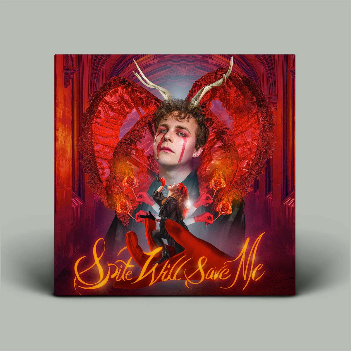 Album cover with a person with red wings and horns, surrounded by flames and text 'Spite Will Save Me' on a gray background.