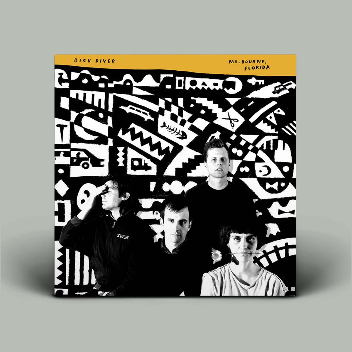 A vinyl record sleeve for Dick Diver's 'Melbourne, Florida' album, displayed standing upright against a neutral gray background. The cover features a bold black and white abstract geometric pattern with a photograph of the band members at the bottom, and a solid mustard yellow top band with the artist's name in black.