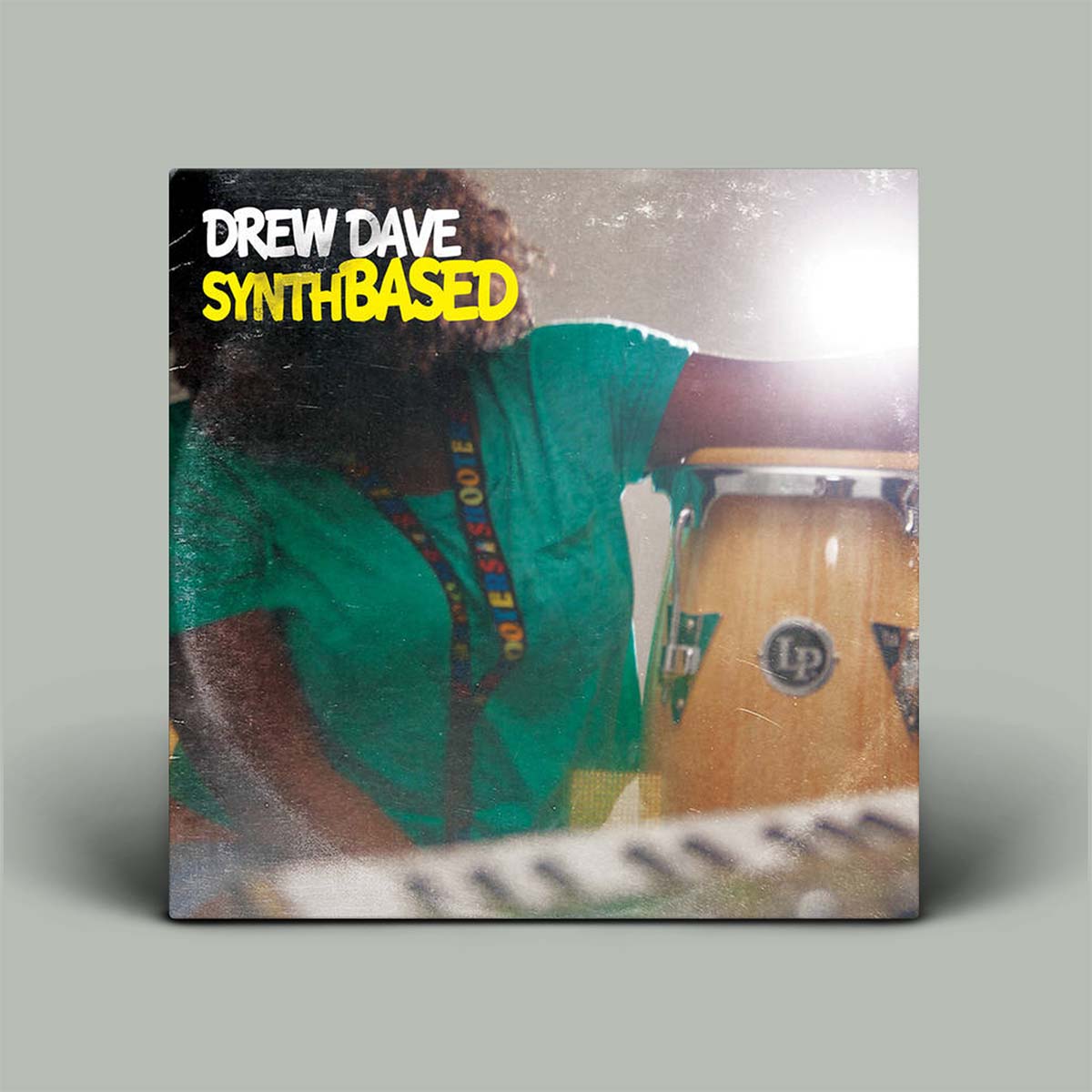 Album cover with a person holding a drum and 'Drew Dave SynthBased' text on a gray background