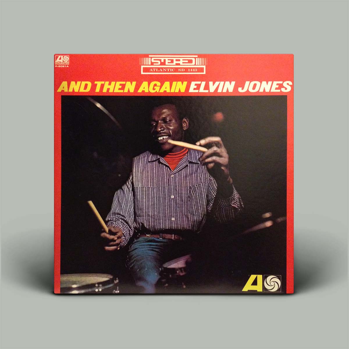 Vinyl record cover featuring a drummer with text 'And Then Again Elvin Jones' on a gray background