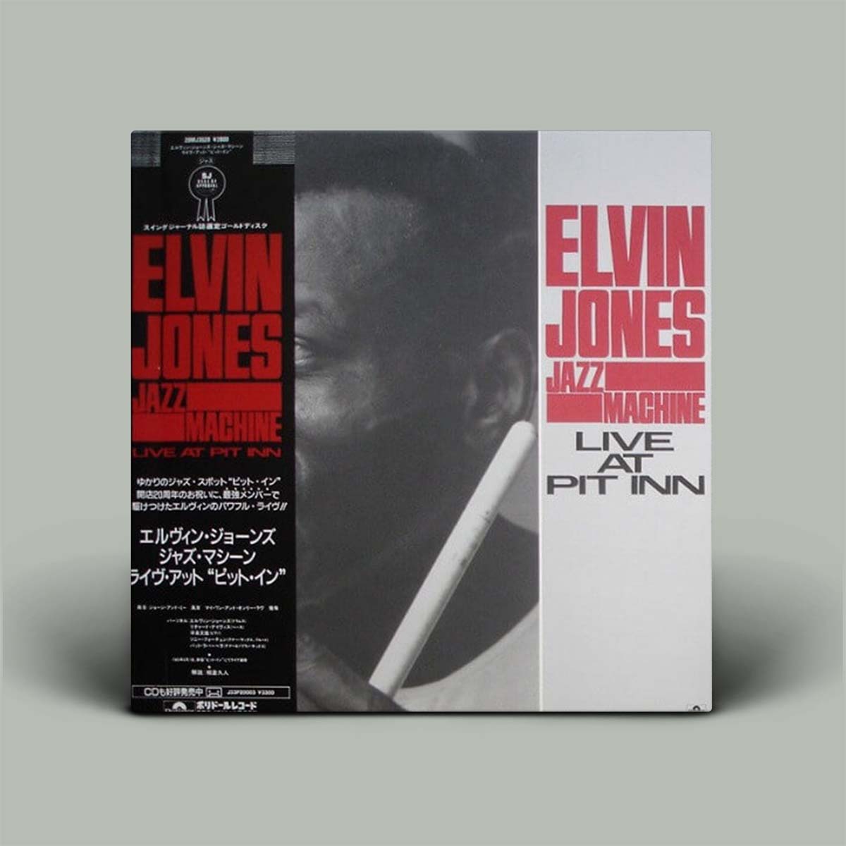 The image shows the album cover of 'Live At Pit Inn' by Elvin Jones Jazz Machine. It features a black and white photo of Elvin Jones with a cigarette, text detailing the album information, and a Japanese tracklist.