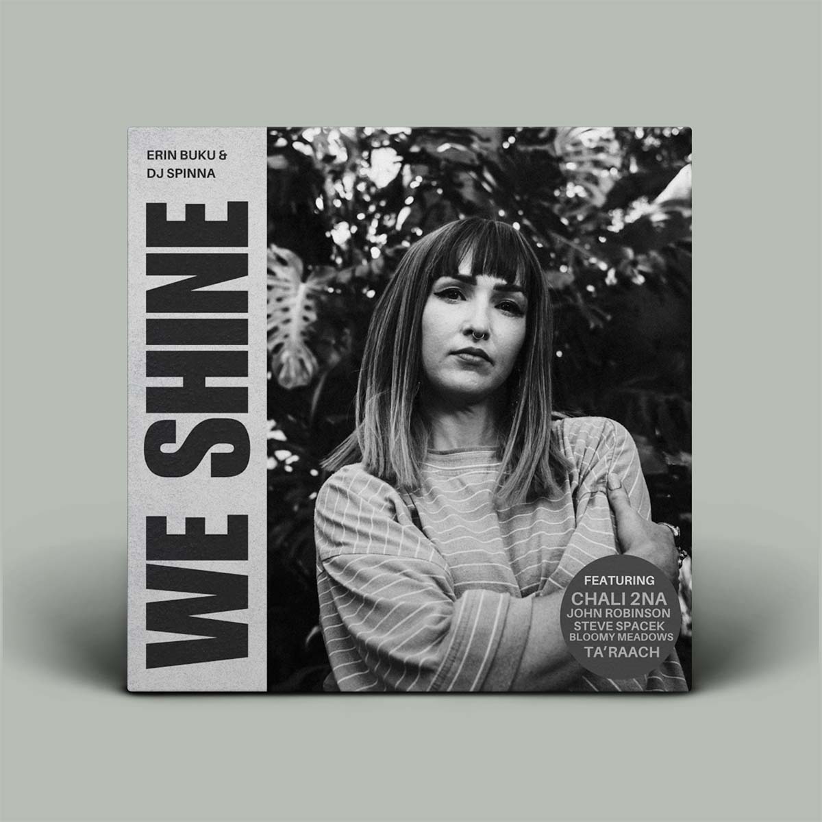 A square music single cover for 'WE SHINE' by Erin Buki & DJ Spinna, featuring a black and white portrait of a woman with bangs. The left side has large vertical text reading 'WE SHINE' on a light gray background, and a black circular badge on the lower right mentions Chaliwa, John Robinson, Steve Spinna, and Ta Raach.