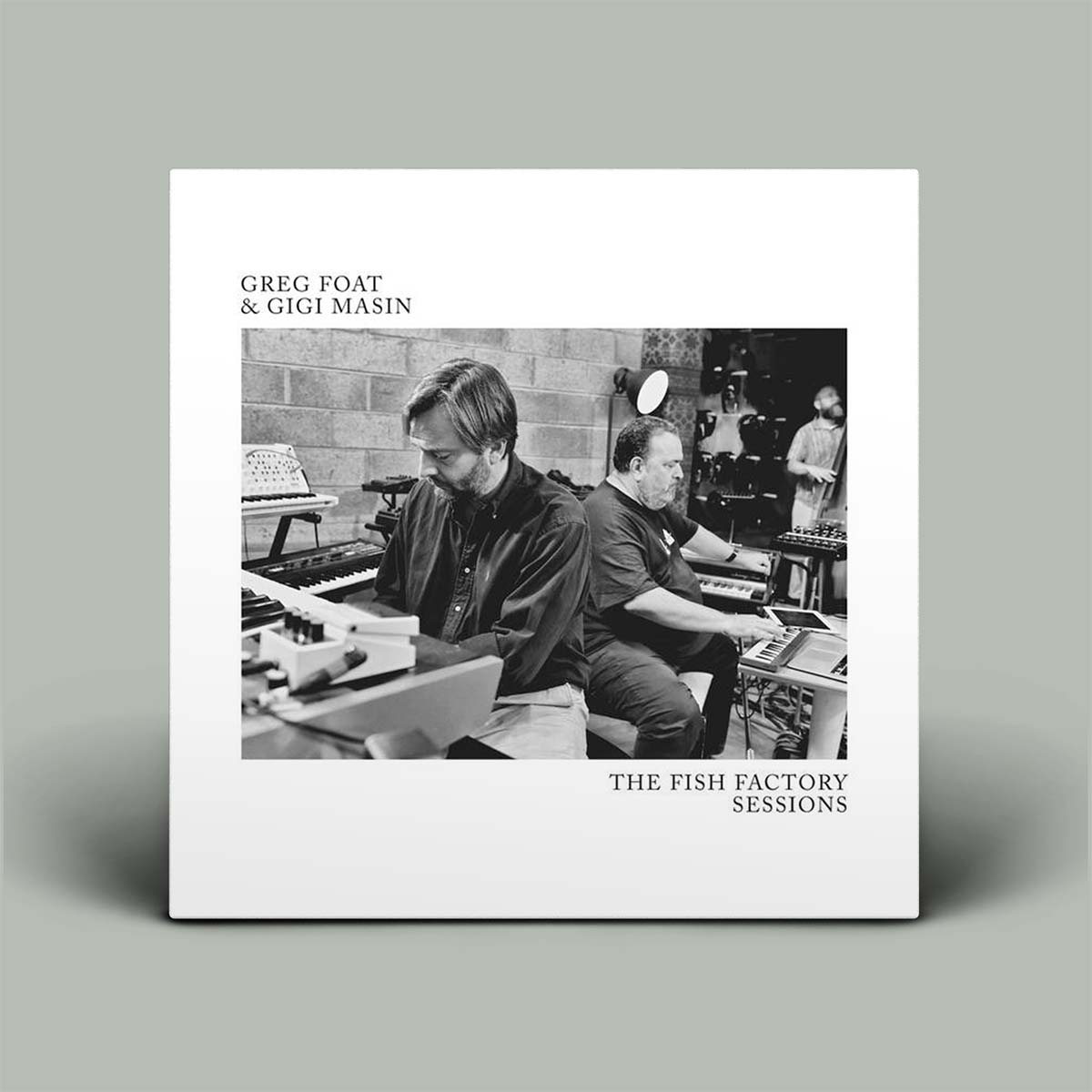 Album cover with two people in a studio setting, featuring text 'Greg Foat & Gigi Masin The Fish Factory Sessions'.