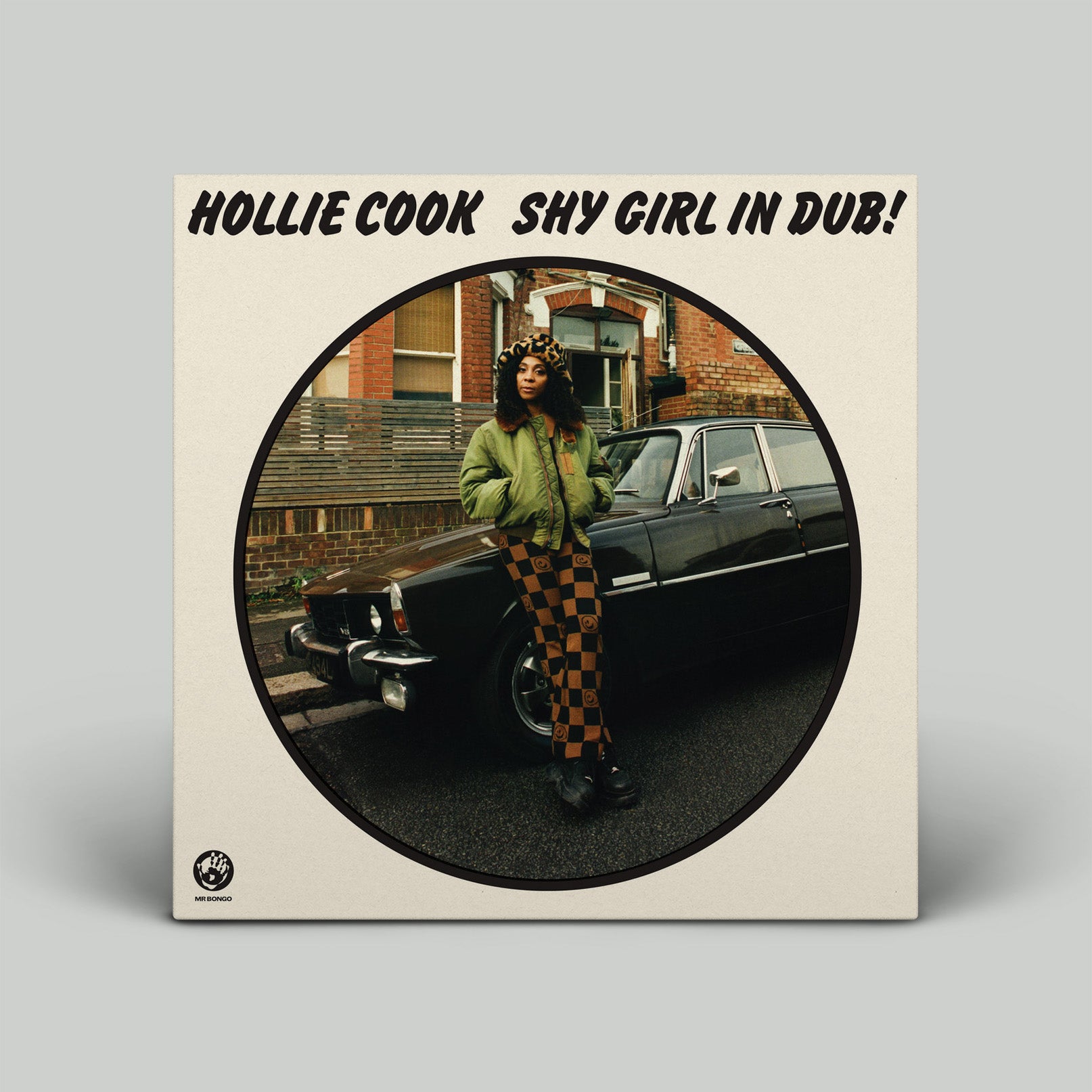 Vinyl record cover featuring a person in front of a car with text 'Hollie Cook Shy Girl in Dub' on a beige background.