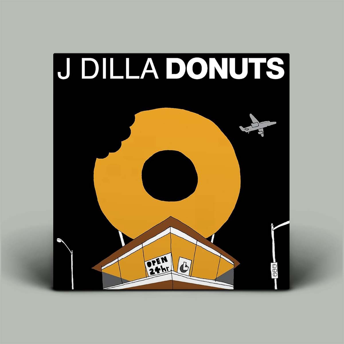 Album cover for 'Donuts' by J Dilla with a large yellow donut, building, and airplane on a black background.