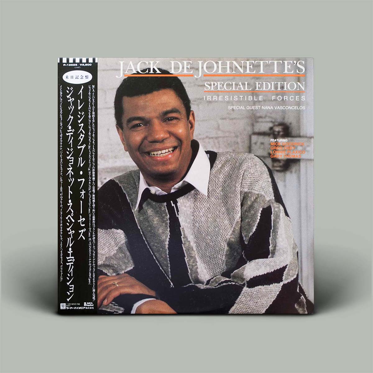 A vinyl record sleeve for Jack De Johnnette's 'Special Edition / Irresistible Force' is shown standing upright against a plain light gray background. The cover features a smiling portrait of the artist in a gray and black knit sweater over a white collared shirt and black tie.