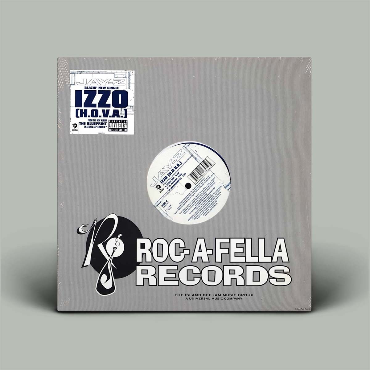 A square vinyl record sleeve for Roc-A-Fella Records, shown standing upright against a plain light gray background. The sleeve is gray with a printed white and black logo, large white 'ROC-A-FELLA RECORDS' text, and a circular cutout revealing part of the record inside.