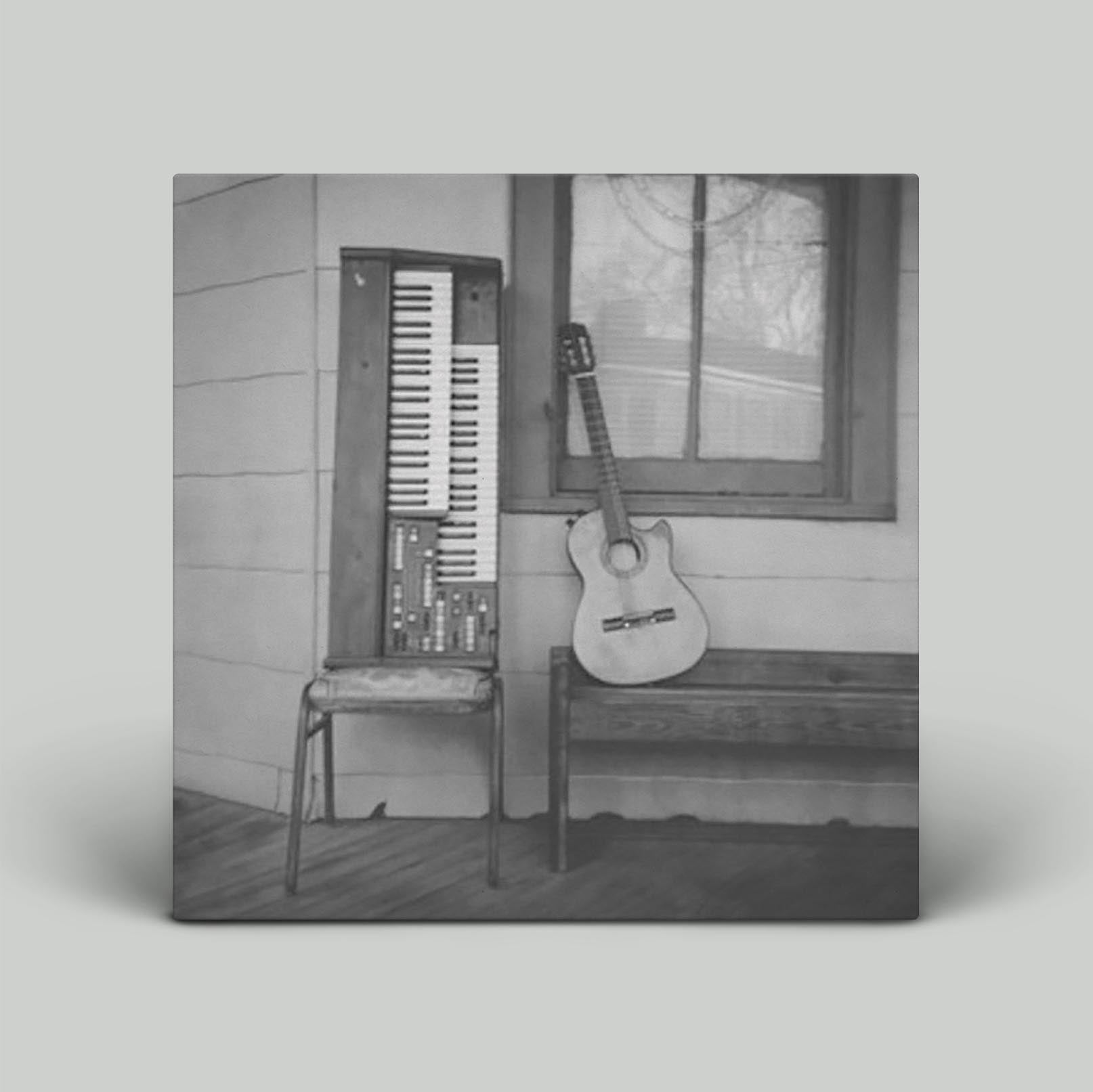 Album cover featuring a piano and a guitar in front of a window, with a black and white color scheme.