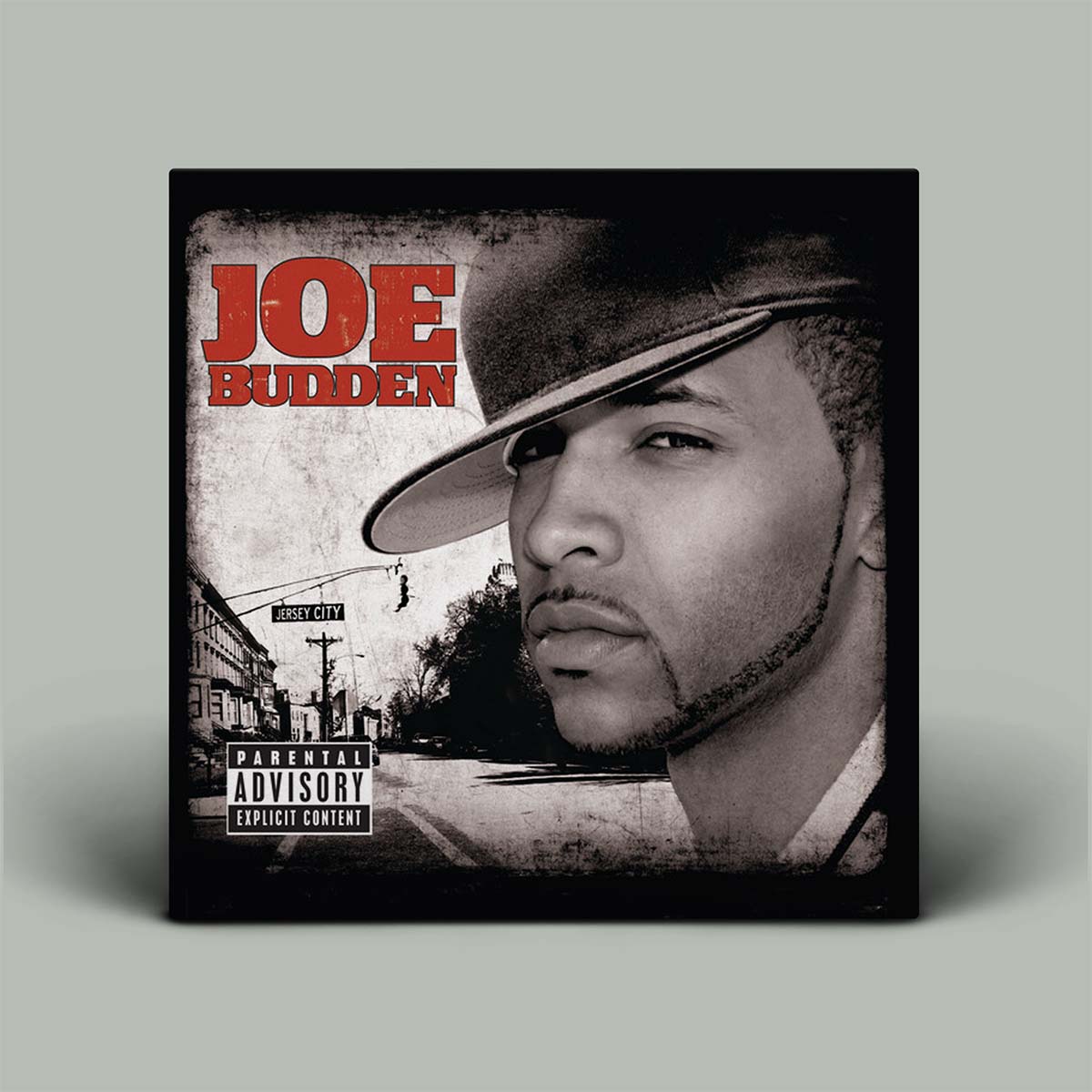 This image features the album cover for "Joe Budden," the debut album by the eponymous rapper. The cover art is striking with its dark, moody background that includes a silhouette of a man's face, presumably Joe Budden, wearing a hat.