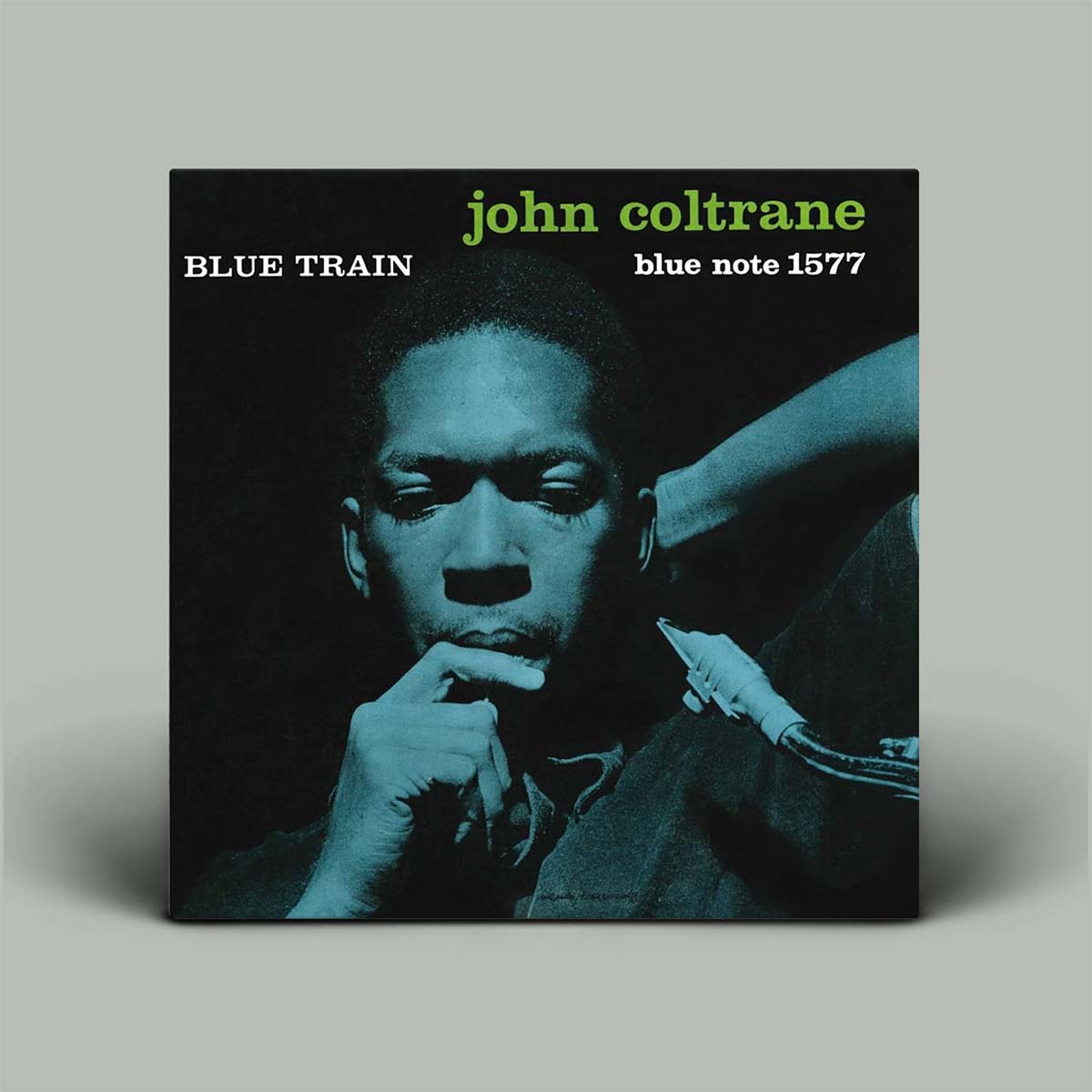 Album cover of John Coltrane's 'Blue Train' with a portrait and text on a gray background