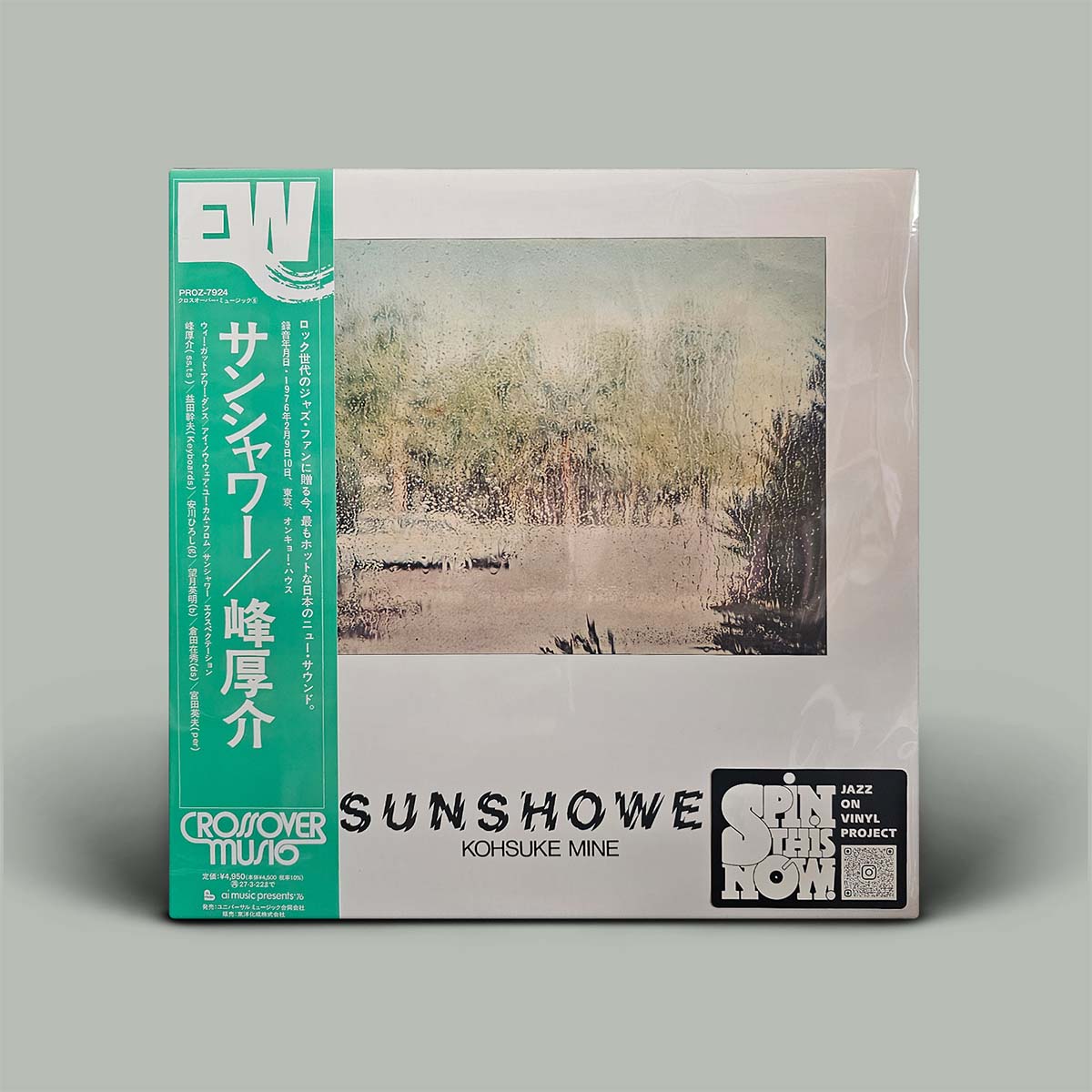 A vinyl record sleeve for Kohsuke Mine's 'Sunshower' project, featuring a green Crossover Music banner on the left, a central landscape photograph, and a black 'Spin Jazzy Now' sticker on the bottom right, set against a solid gray background.