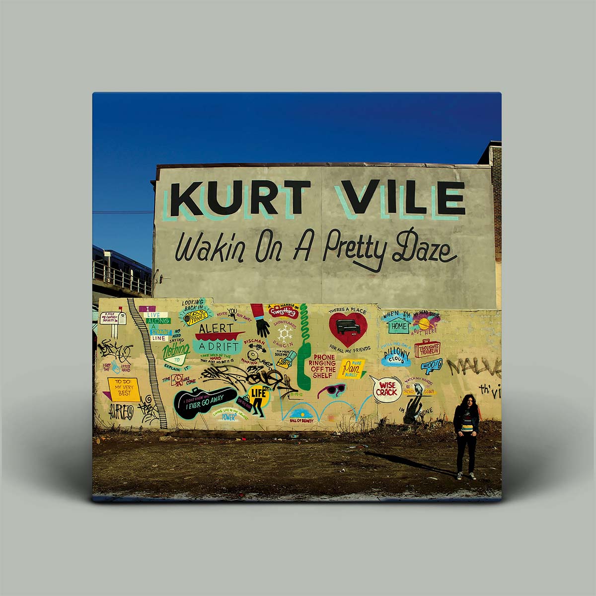 Album cover with Kurt Vile mural and text 'Wakin On A Pretty Daze' on a gray background