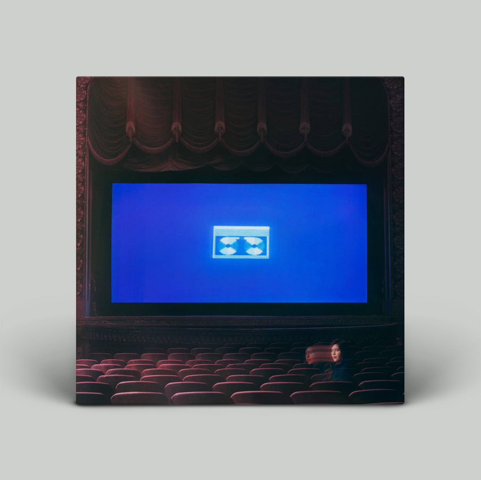Theater auditorium with a blue screen and red seats on a gray background
