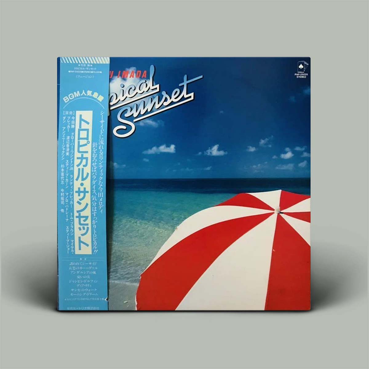 Vinyl record cover with a beach scene and red and white umbrella, featuring Japanese text.