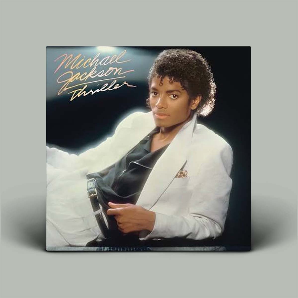 Michael Jackson Thriller vinyl record album cover shown as a square product on a light gray background. The cover features a portrait of Michael Jackson in a white blazer and black shirt, with gold script text reading 'Michael Jackson Thriller' in the upper left.