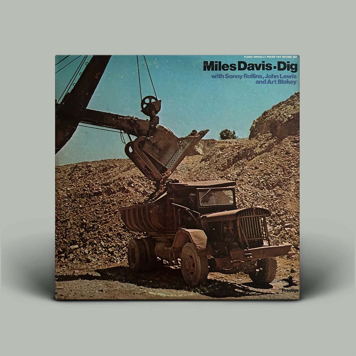 Miles Davis - Dig vinyl record album cover, featuring a vintage dump truck and excavator in a quarry scene, shown as a square album sleeve on a light gray background.