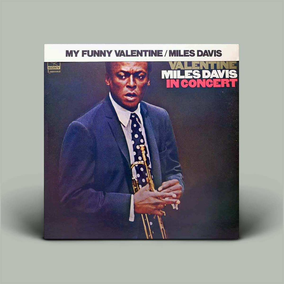 Vinyl album cover featuring Miles Davis with a trumpet on a gray background